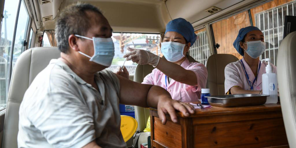 Veículos de vacinação móvel prestams serviço na área rural de Guangxi, China