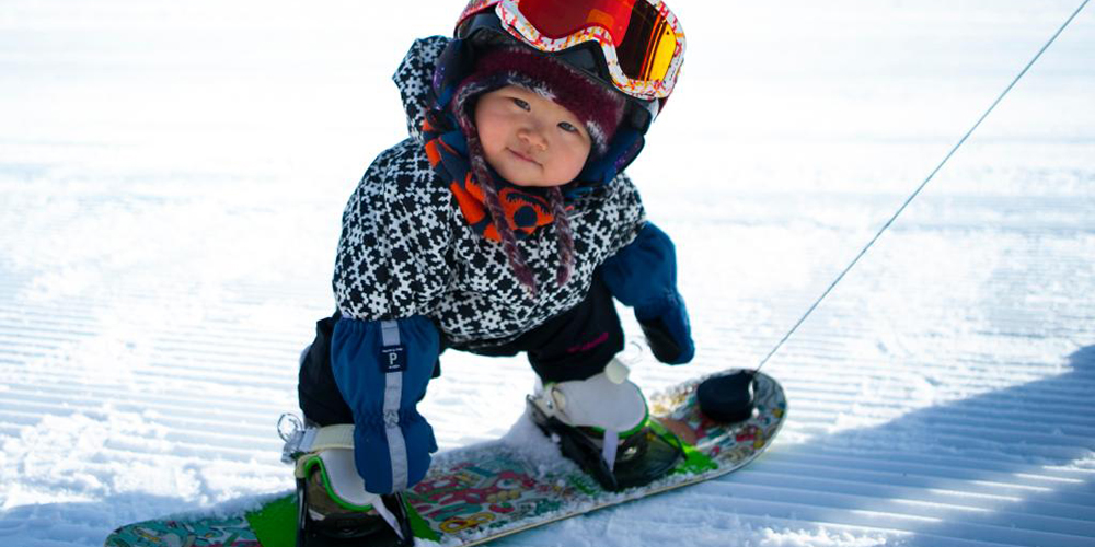 Menina de 11 meses pratica esqui na estação Thaiwoo em Hebei