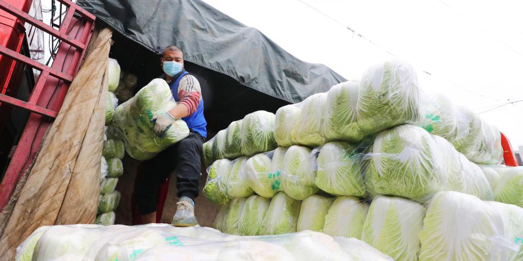 Comerciantes e funcionários trabalham duro para garantir fornecimento de vegetais de moradores locais durante o Festival da Primavera em Shanghai